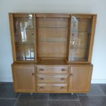 An Ercol Golden Dawn blonde elm sideboard with glazed two door top over two cupboards and three