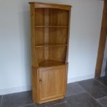 An Ercol Golden Dawn blonde elm corner cupboard with an open rack top above a single cupboard door -