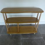 An Ercol Golden Dawn elm three tier side table book/magazine stand - Height 72cm x 91cm x 32cm -