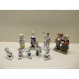 A group of three porcelain Continental figures, a Sitzendorf group and a five piece Putti band - all