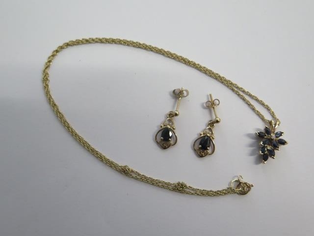 A 9ct yellow gold sapphire pendant on a chain and a pair of sapphire earrings - total approx