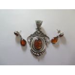 A silver amber pendant and a pair of earrings