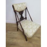 An asthetic movement mahogany nursing chair in the style of Christopher Dresser, reupholstered but