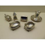 A silver pepper mill on a silver stand, a three piece silver cruet and a pair of silver salts -