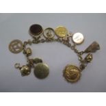 A 9ct yellow gold charm bracelet with 10 charms, a masonic fob, Victorian gold full sovereign coin