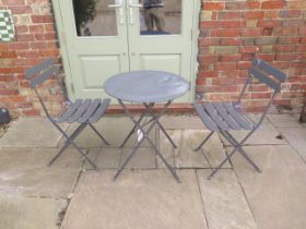 A grey metal folding patio table and chairs