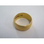 A hallmarked 22ct yellow gold band ring size N - 8mm band - approx weight 9.4 grams - some usage