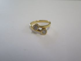 An 18ct yellow gold two stone diamond crossover ring size L - approx weight 3.6 grams - in good