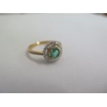 A hallmarked 18ct yellow gold emerald and diamond Halo ring size O - the central emerald approx 0.