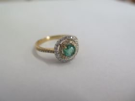 A hallmarked 18ct yellow gold emerald and diamond Halo ring size O - the central emerald approx 0.