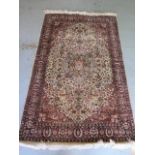 A fine woven silk mix rug with cream field and foliate design - 196cm x 120cm - some wear mainly