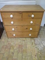 A Victorian stripped pine five drawer chest with ceramic handles - Height 85cm x 97cm x 45cm