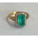 A good yellow gold emerald and diamond ring - The central rectangular round corner step cut