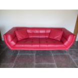 A designer red leather two seater sofa with two cushions - Height 75cm x 234cm x 92cm - in