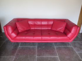 A designer red leather two seater sofa with two cushions - Height 75cm x 234cm x 92cm - in