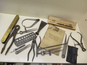 A collection of Military instruments and tools all marked with arrow, also War Dept Handbook tool