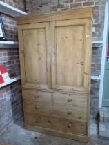 A Victorian stripped pine linen press with a two door top enclosing two slides above a four drawer