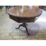 An oak circular drum table with leather inset top over a hexagonal frieze with three active