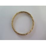 A 9ct yellow gold hinged bangle - 6cm x 6.5cm external - approx weight 8.3 grams - some usage wear
