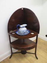 A Georgian mahogany corner washstand with a folding gallery top and base drawer with a modern blue