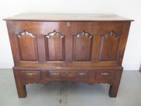 An 18th century oak mule chest with panelled front and three base drawers with lift out two plank
