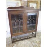 An oak glazed leaded two door bookcase on barley twist supports - Height 134cm x 110cm x 134cm - all