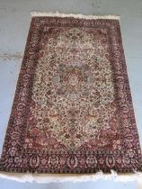 A fine woven silk mix rug with cream field and foliate design - 196cm x 120cm - some wear mainly