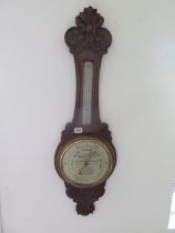 An advertising carved walnut aneroid barometer with thermometer 'Harry Hall The Tailor and Habit