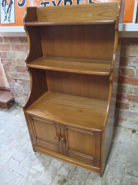 An Ercol waterfall bookcase with two base drawers - Height 102cm x Width 61cm
