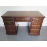 A Victorian walnut nine drawer one piece pedestal desk with tooled leather writing surface -