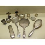 A collection of silver items including serviette rings, silver back brush and mirror etc - total
