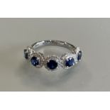 A platinum 5 stone sapphire and diamond ring, the sapphires are well matched and of a good colour,