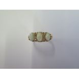 An 18ct yellow gold three stone opal ring set with small diamonds - ring size N - approx weight 4.