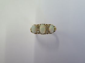 An 18ct yellow gold three stone opal ring set with small diamonds - ring size N - approx weight 4.