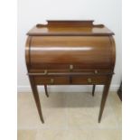 An Edwardian inlaid mahogany cylinder top writing desk with a fitted interior over two frieze