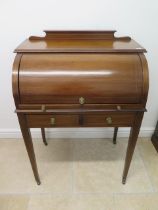An Edwardian inlaid mahogany cylinder top writing desk with a fitted interior over two frieze