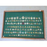 A mounted and framed display of British Military cap badges - 117 in total - 65cm x 95cm