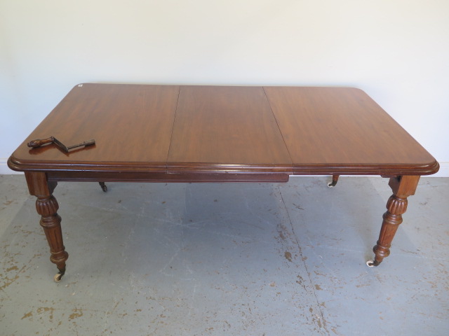 A Victorian mahogany windout dining table with one leaf on turned fluted legs - Height 73cm x