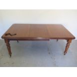 A Victorian mahogany windout dining table with one leaf on turned fluted legs - Height 73cm x