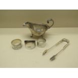 A silver sauce boat, three silver napkin rings and a Victorian silver sugar nip - total approx