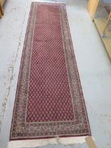 A woollen runner with a red field - 310cm x 82cm - in good condition