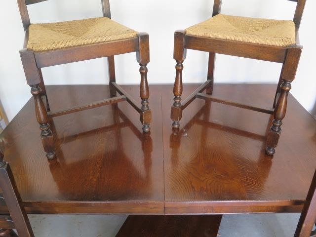 An oak pull out dining table with one extra leaf and four rush seated chairs - Table 74cm tall x - Image 2 of 3