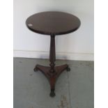 A mahogany wine table on a turned fluted column, platform base and cast iron claw feet - Height 73cm