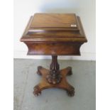 An early Victorian walnut teapoy on a shaped column and quatrefoil platform base with relined