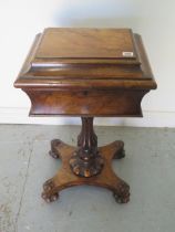 An early Victorian walnut teapoy on a shaped column and quatrefoil platform base with relined