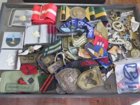 A collection of assorted Military badges, belts and buckles