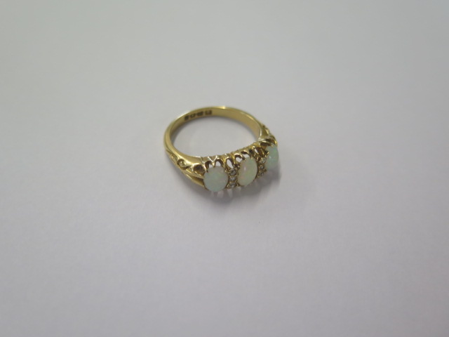 An 18ct yellow gold three stone opal ring set with small diamonds - ring size N - approx weight 4. - Image 2 of 4