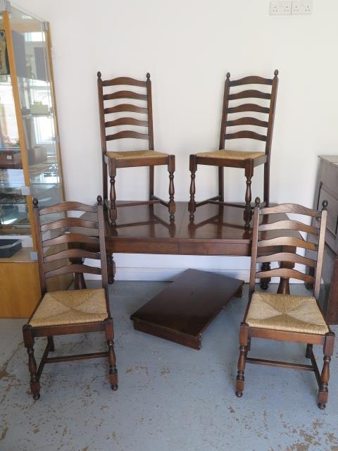 An oak pull out dining table with one extra leaf and four rush seated chairs - Table 74cm tall x