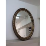 An oval gilt mirror - 89cm x 63cm