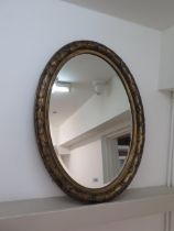 An oval gilt mirror - 89cm x 63cm